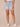 Light Blue Artisanal Denim Absolution High Rise Roll Cuff Spade Back Pocket Distress Whiskering Short